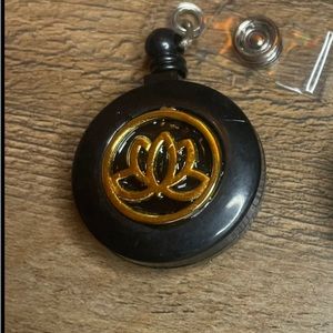 Self retracting badge holder with lotus flower charm